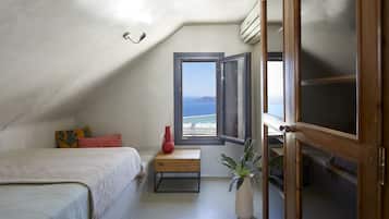 Enjoy a scenic sea view from the comfort of this cozy room, featuring a bed, nightstand, and potted plant.