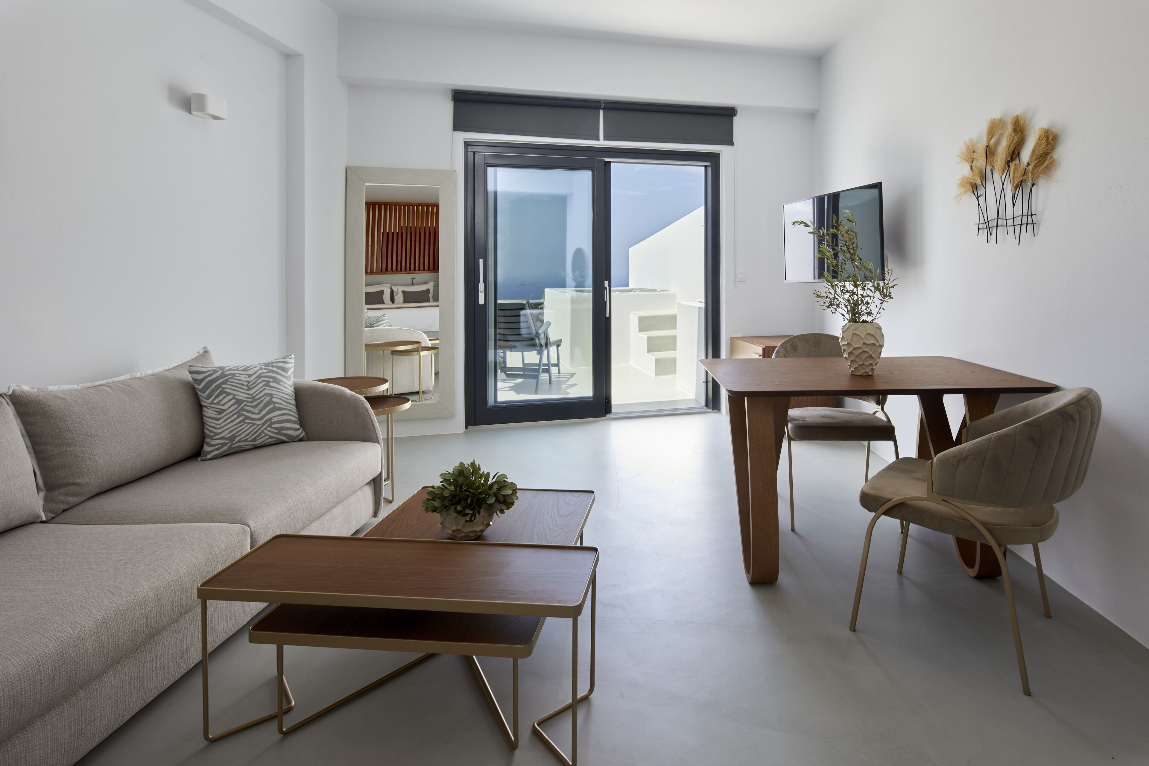 A modern living room with a sofa, coffee table, and dining area.