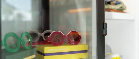 A display case with a pair of glasses on a yellow box labeled 'FRAME YOUR WORLD'.