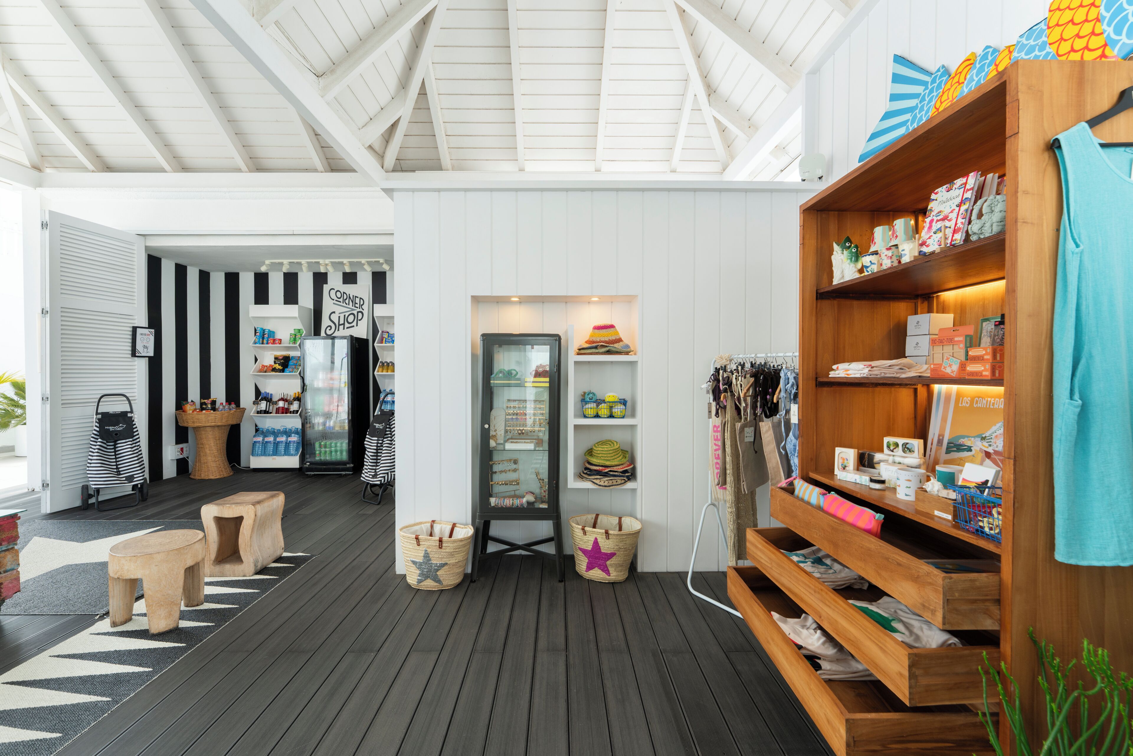 A beach-themed shop with wooden shelves, a display case, and a variety of items.