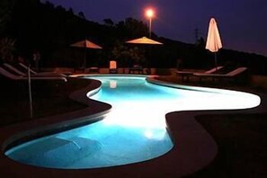 Una piscina al aire libre de temporada, sombrillas