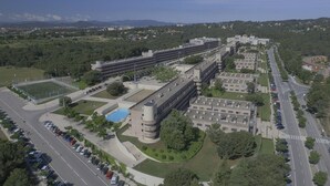 Vue aérienne d’un vaste complexe immobilier comprenant de nombreux parkings, une piscine et des espaces verts environnants.