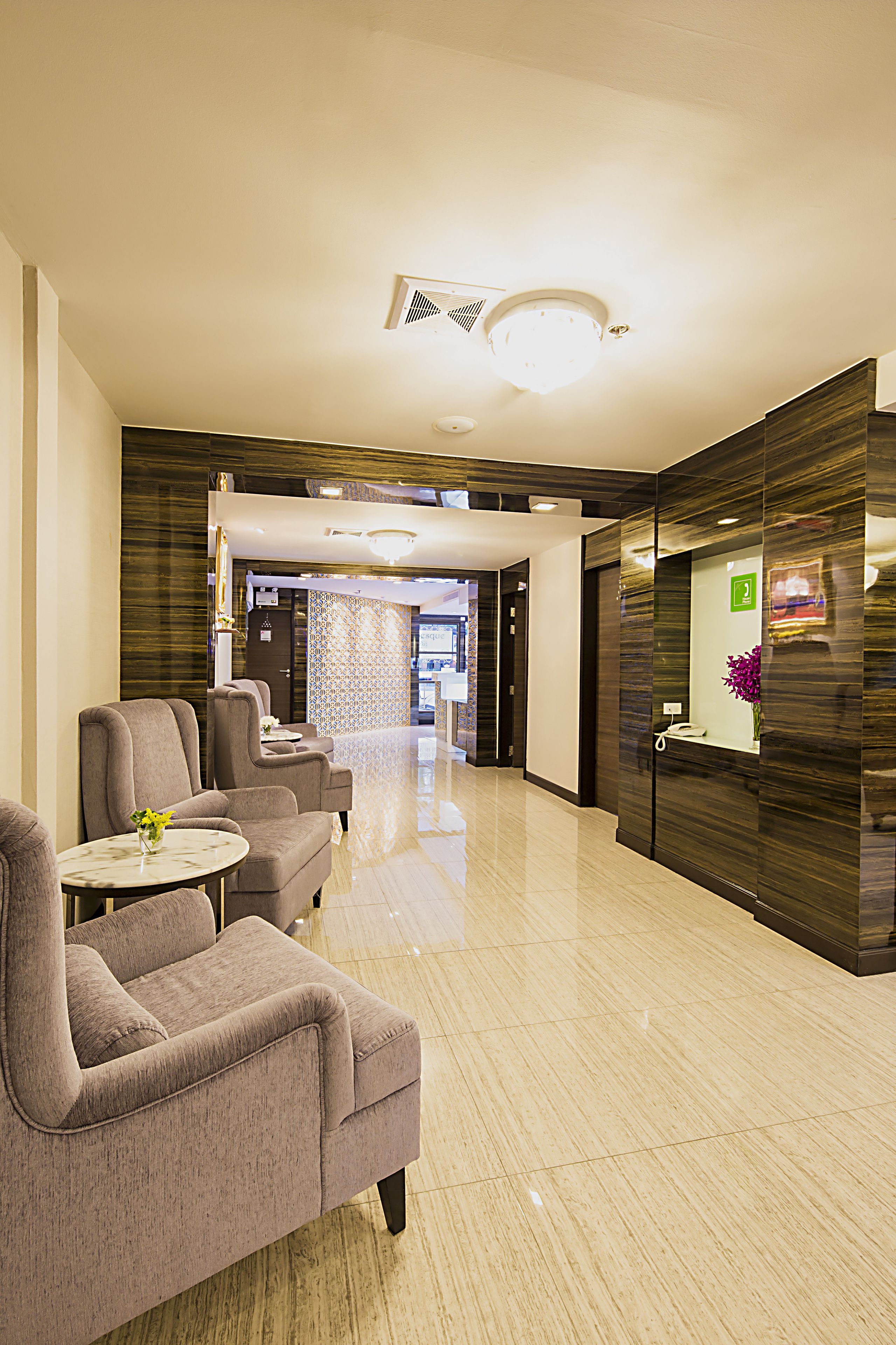 Un vestíbulo de hotel con mostrador de recepción, zona de estar y diseño moderno.
