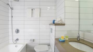 A modern bathroom with a bathtub, toilet, and shower.