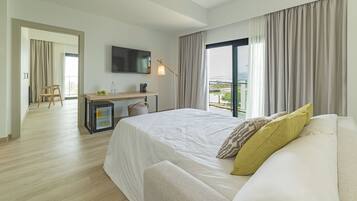 Una habitación de hotel moderna con una cama grande, un escritorio con una silla, un televisor y un balcón con cortinas.
