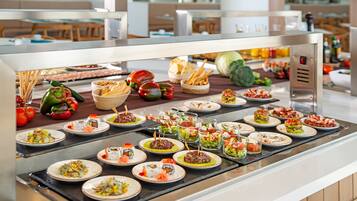 A buffet with various dishes, including sushi, salads, and bread.