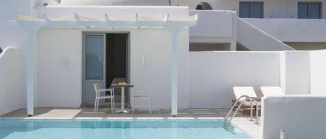 Una piscina al aire libre, sombrillas, tumbonas