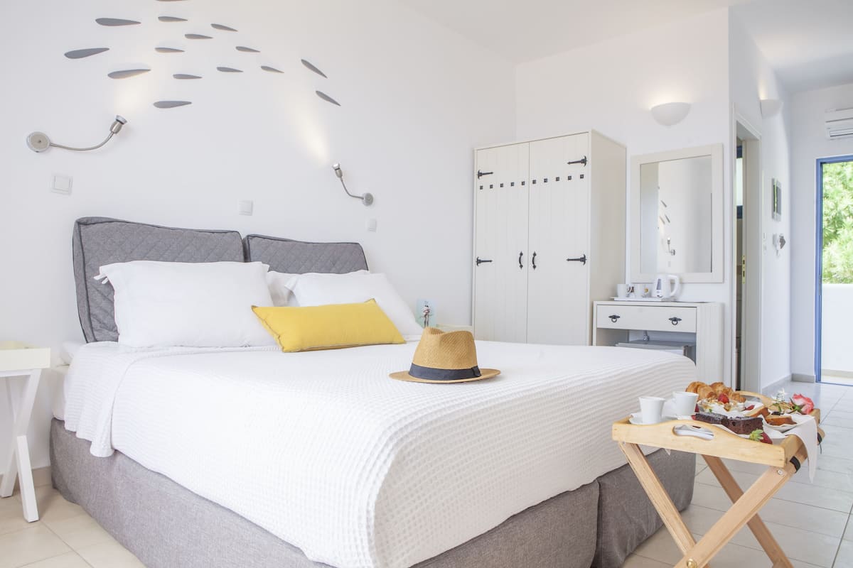 A bedroom with a bed, bedside table, wardrobe, and a breakfast tray.