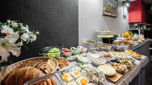A buffet with various food items including bread, eggs, salads, and fruits. - Hotel Delta (Kraków)