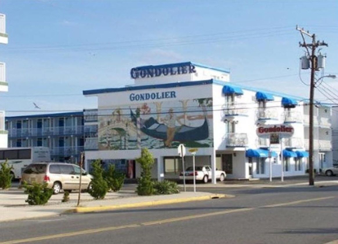 Un edificio con un letrero que dice 'Gondolier', que presenta un mural de un bote y agua.