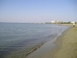 Una playa cerca, sillas reclinables de playa, sombrillas