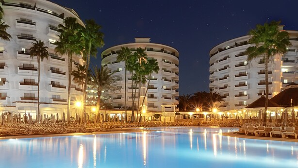 A hotel with a large swimming pool, multiple balconies, and palm trees. - Servatur Waikiki (San Bartolomé de Tirajana)