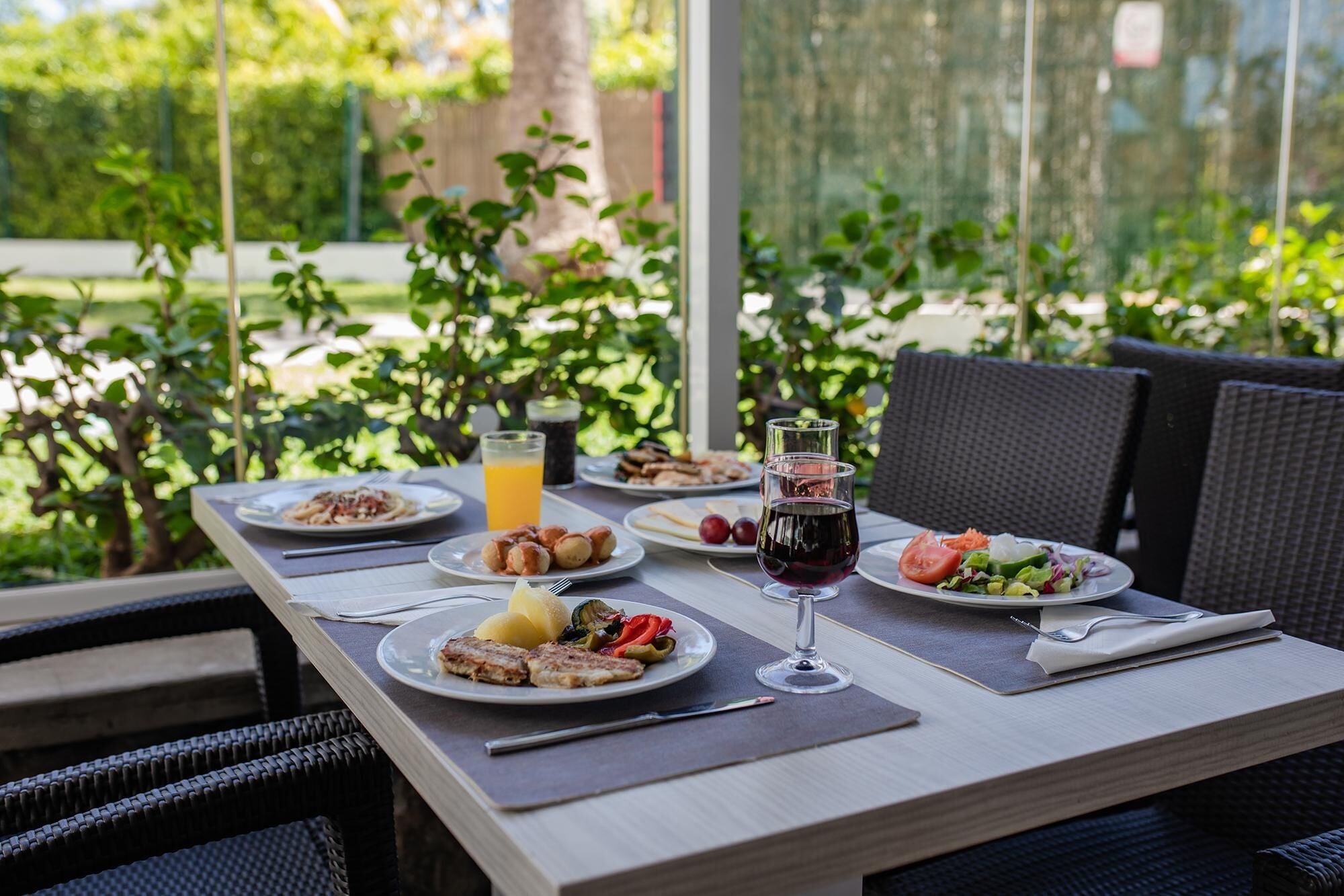 A table set with various dishes, drinks, and cutlery, likely in a restaurant or cafe setting.