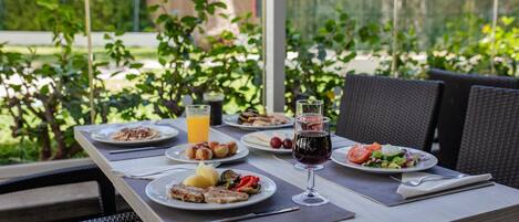 A table set with various dishes, drinks, and cutlery, likely in a restaurant or cafe setting.