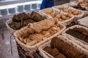 Diversa variedad de panes y pasteles expuestos en cestas.