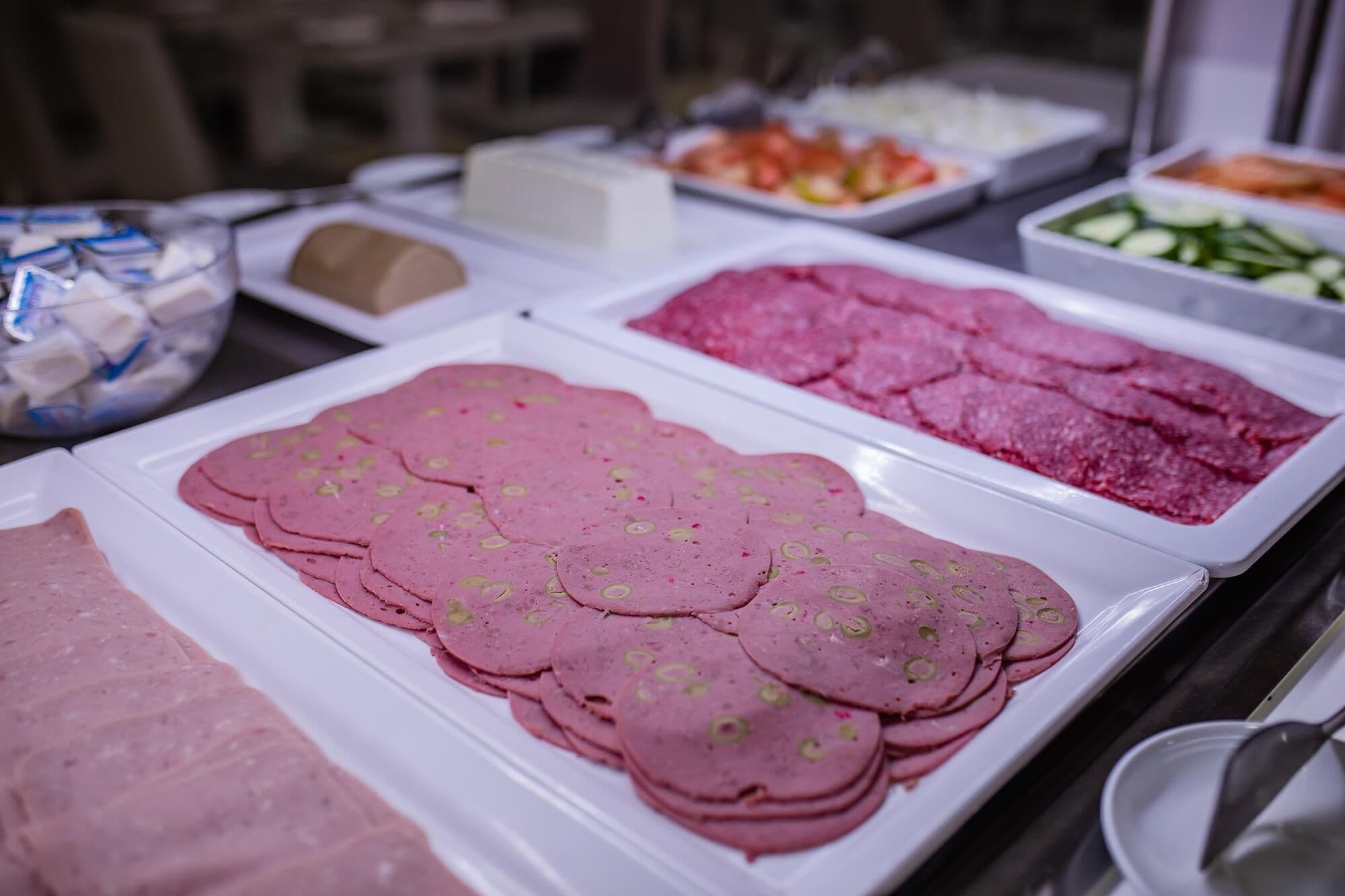 A buffet with various food items including sliced meats and vegetables.