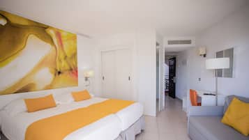 Quarto de hotel com uma cama grande, uma escrivaninha e um sofá.