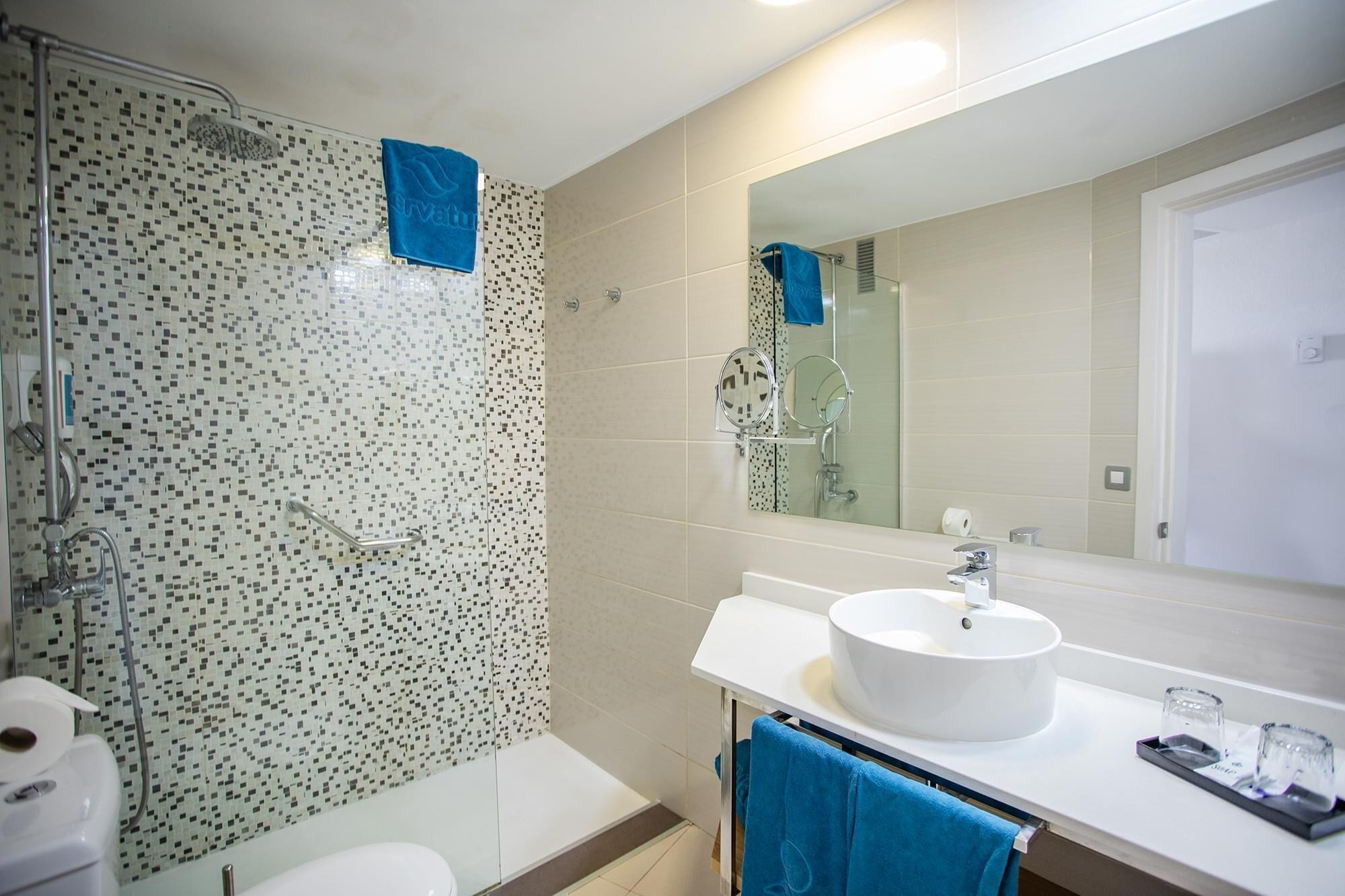 Un baño con ducha, inodoro y lavamanos.