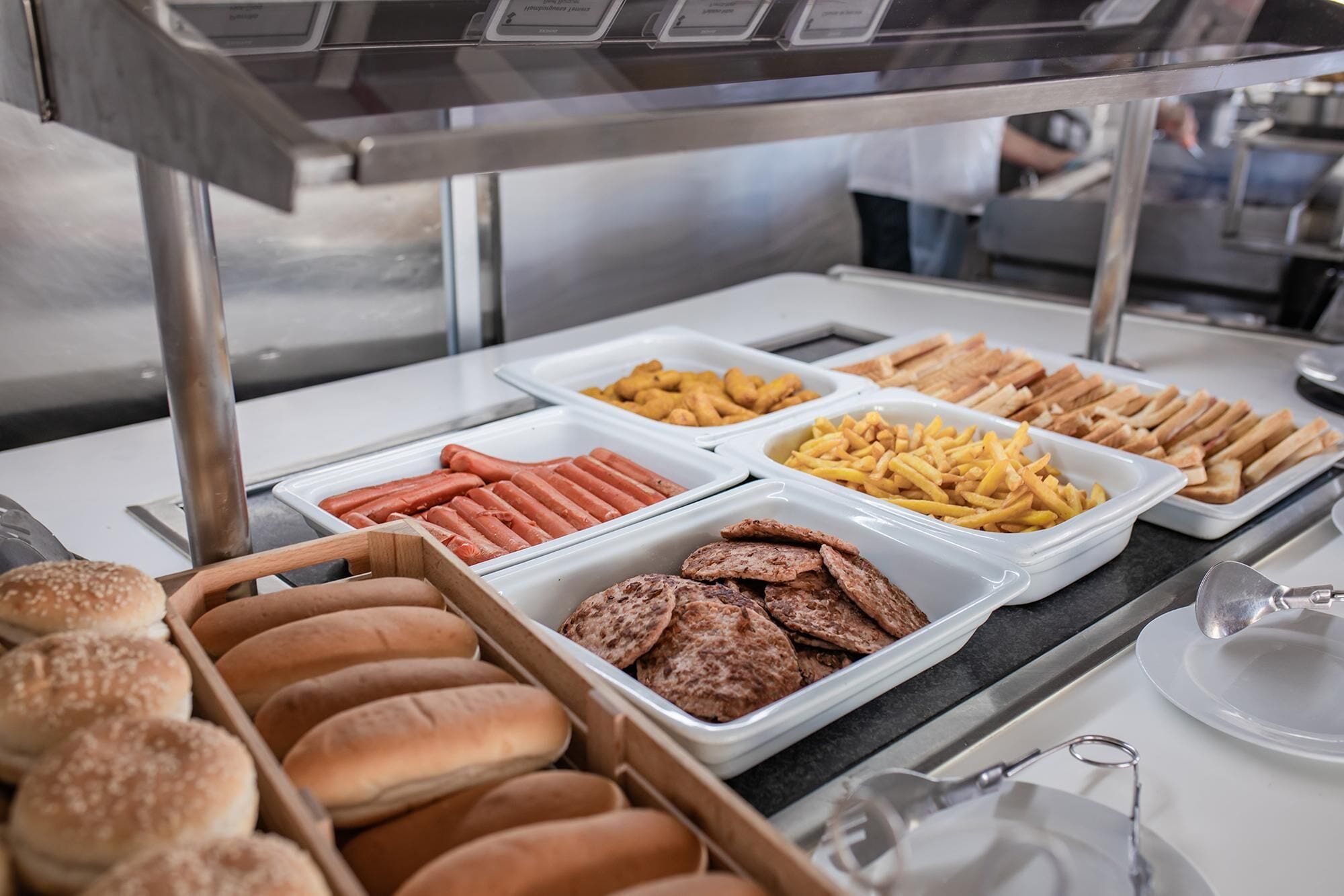 A buffet with hot dogs, French fries, and various sandwiches.