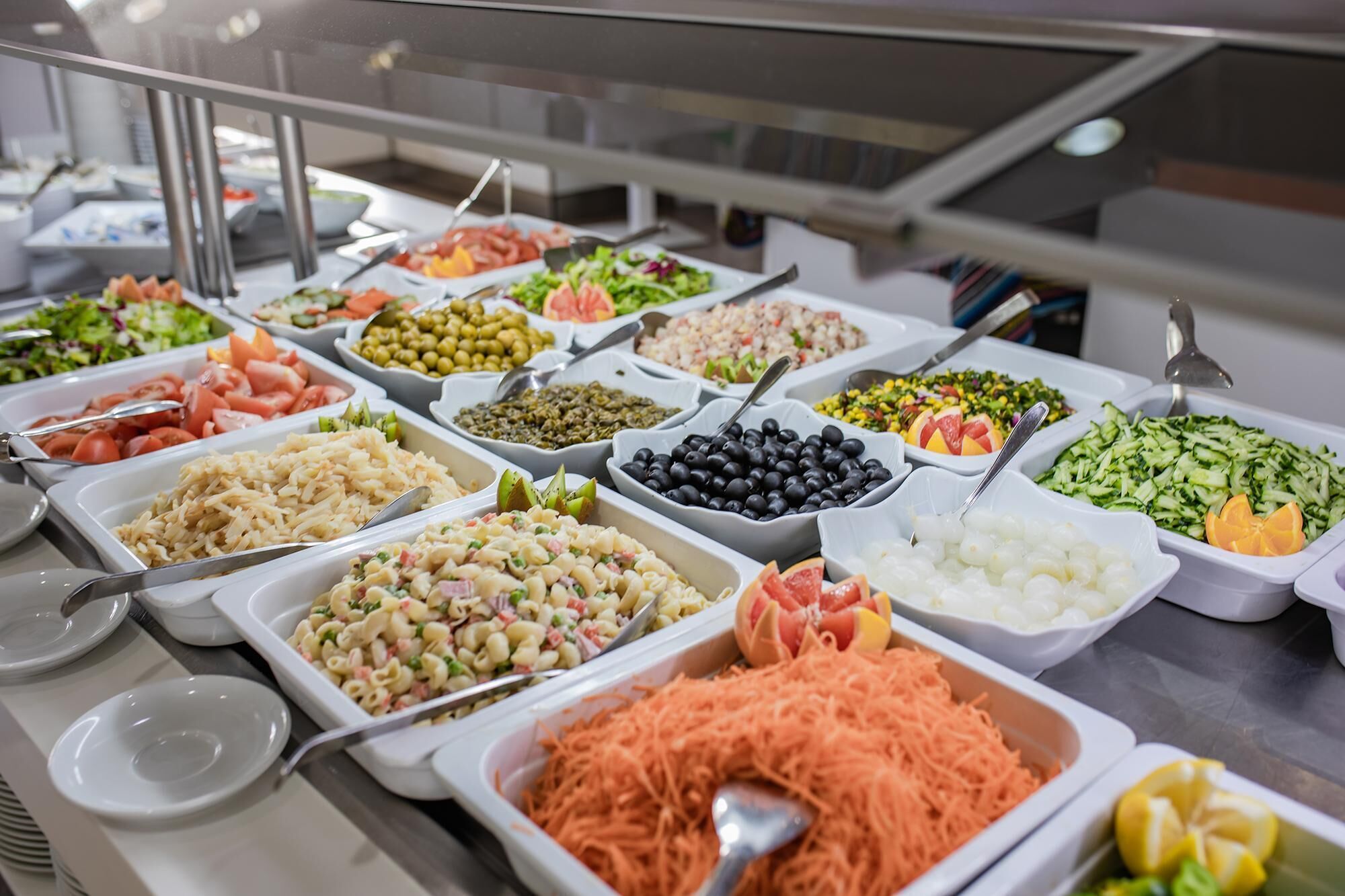 A buffet with various dishes including pasta, salads, and vegetables.