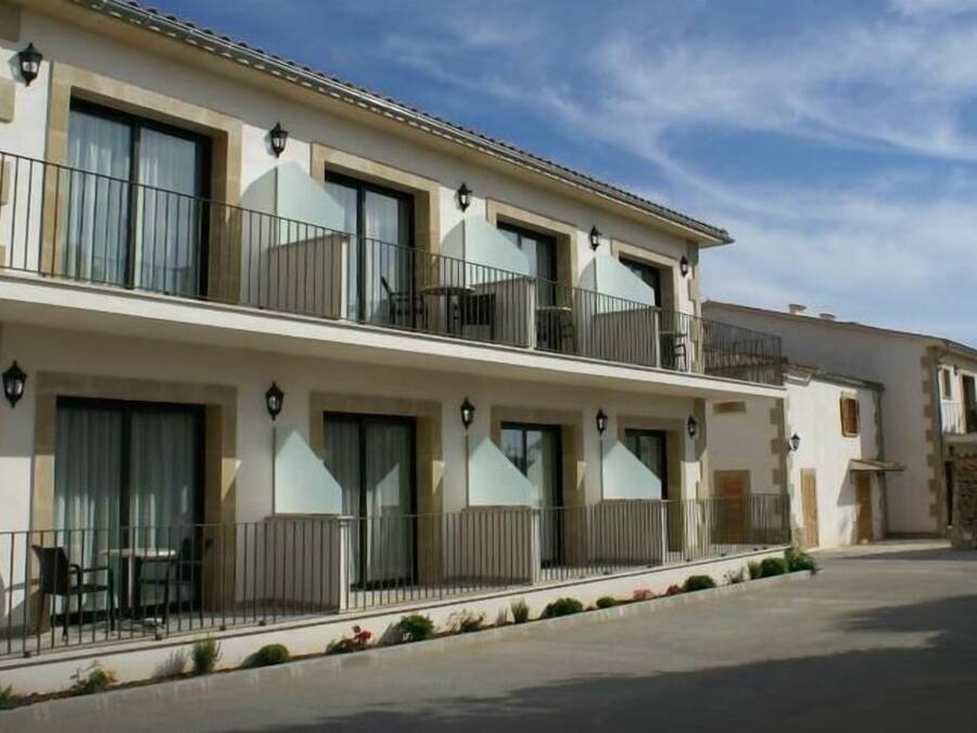 A multi-story hotel with balconies, large windows, and outdoor seating.
