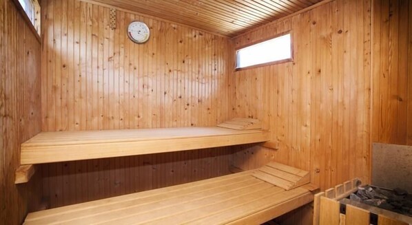 Un sauna en bois avec deux bancs et une petite fenêtre.