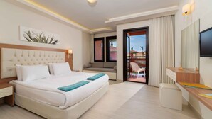 A hotel room with a bed, a desk, a chair, a TV, and a balcony with a view. - Sundia By Liberty Suncity - All inclusive (Fethiye)