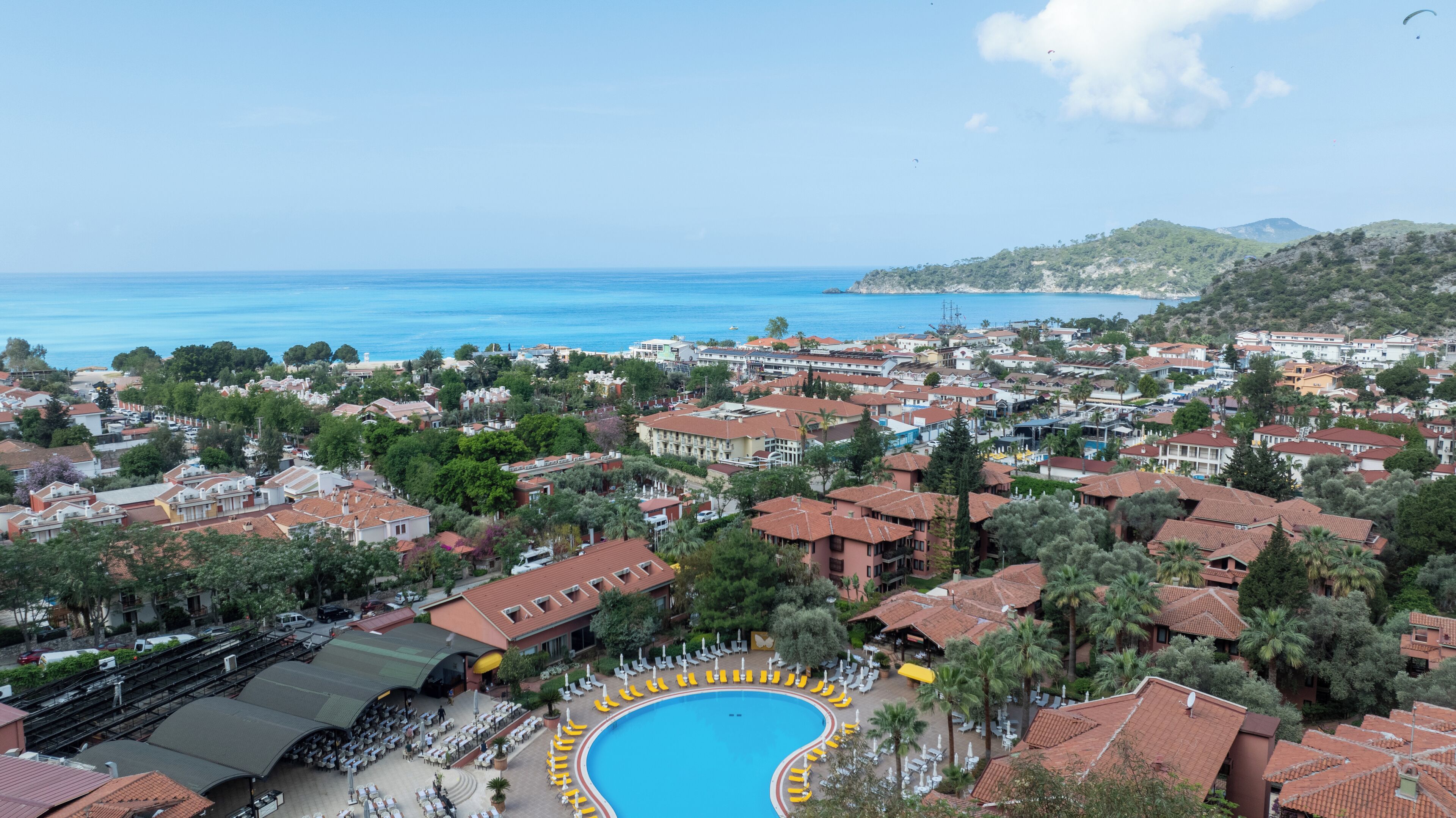 Un resort con una gran piscina, varias edificaciones y vista al mar.