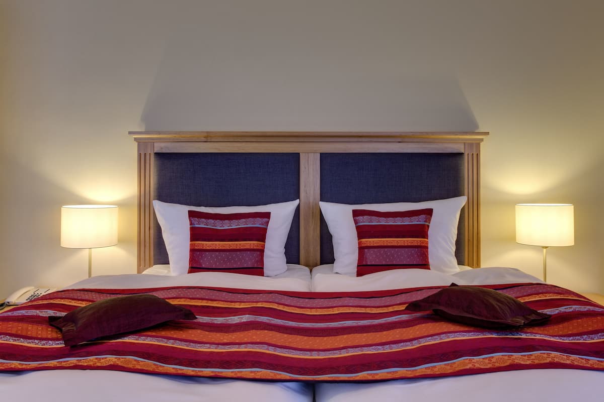 A bed with a striped blanket, two pillows, and a wooden headboard.