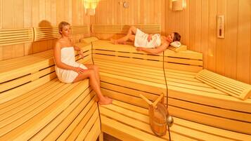A sauna with wooden benches and a wooden bucket.
