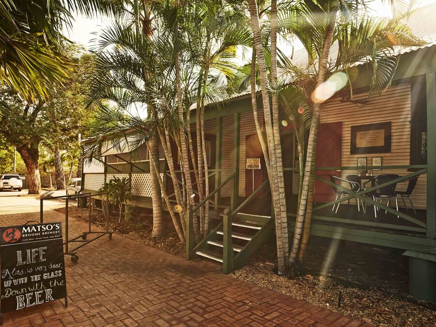A brick pathway leading to a building with a signboard for Matso's Broome Brewery.