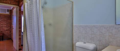 Un baño con ducha, inodoro y lavamanos.