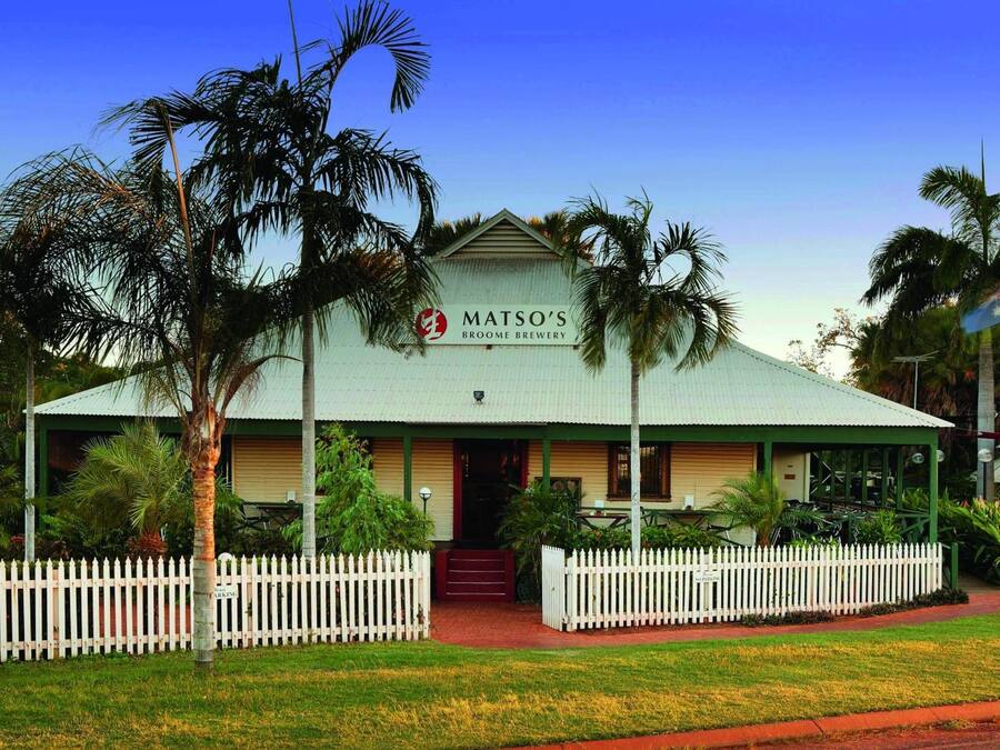 A building with a sign reading "MATSO'S BROOME BREWERY" and a white picket fence in front.