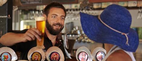 Un bar con varias griferías de cerveza y una pizarra con el menú al fondo.