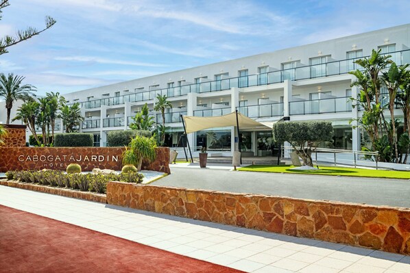 A modern hotel with a stone facade, multiple balconies, and a well-maintained garden area. - Cabogata Jardín Hotel (Almeria)