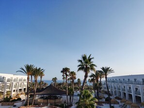 A resort with a central pavilion, palm trees, and a sea view. - Cabogata Jardín Hotel (Almeria)