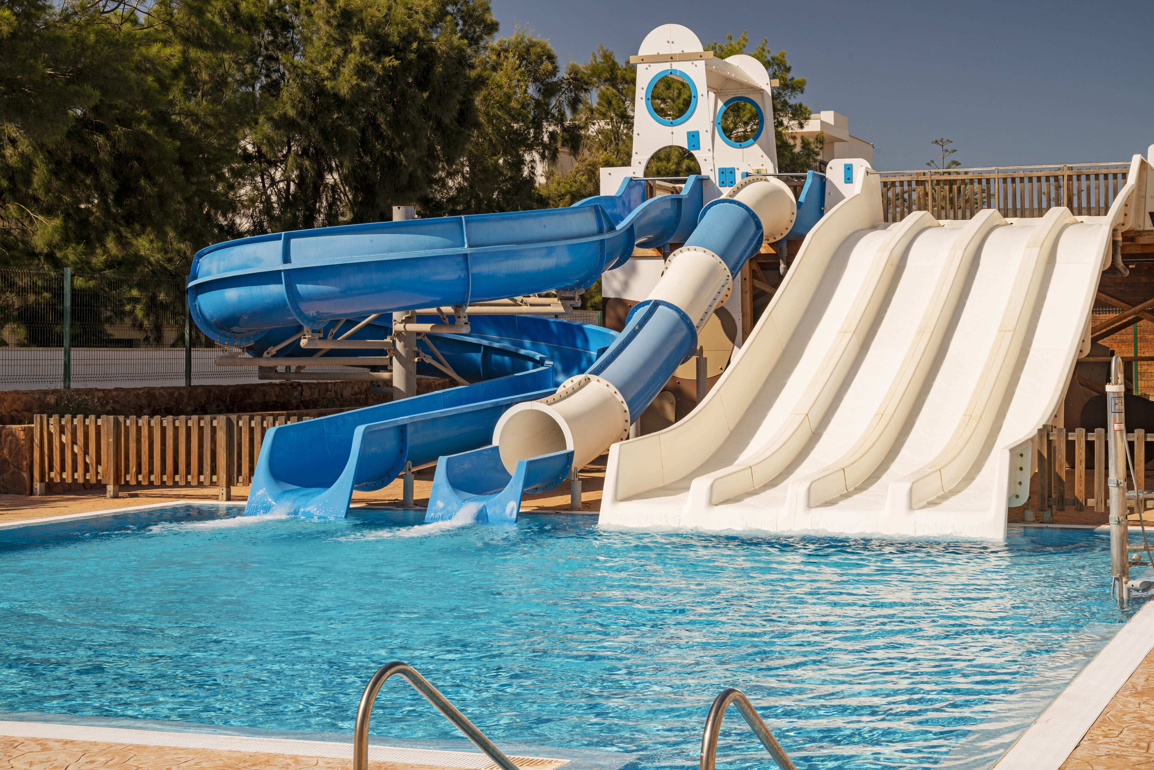 A water park with multiple slides over a swimming pool.