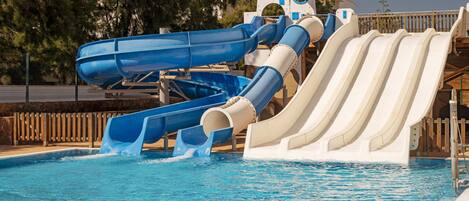 A water park with multiple slides over a swimming pool.