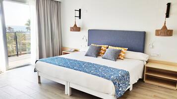 Una habitación de hotel moderna con una cama grande, vistas al exterior y un balcón.