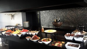 Un buffet proposant une variété de plats et un bar avec des bouteilles.