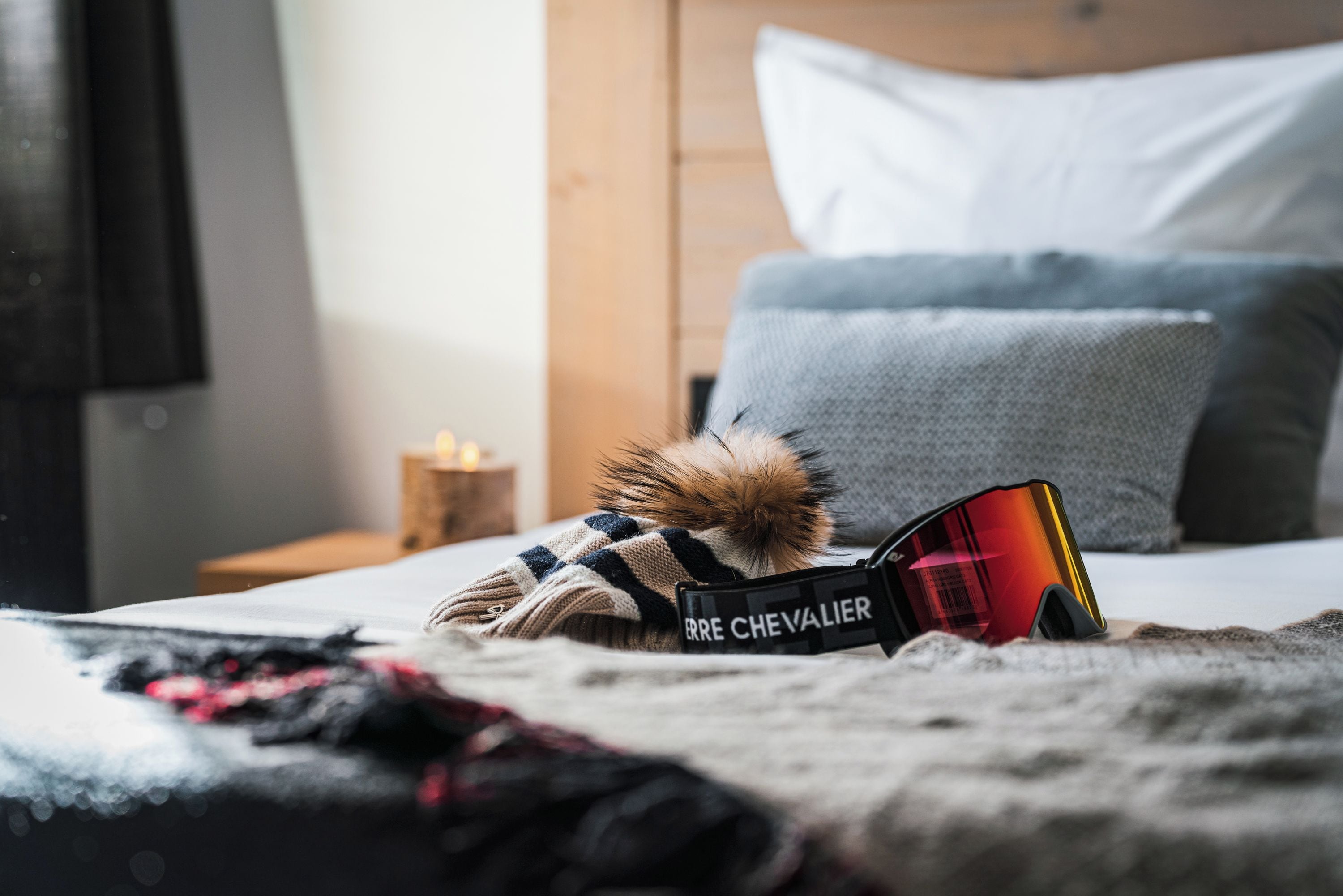 Een bed met een paar zonnebrillen en een bont accessoire.