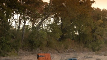 A picnic setup on a blanket with a lantern, a wooden box, and a metal bucket.