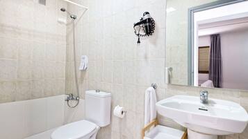 Un baño con inodoro, lavabo y ducha.
