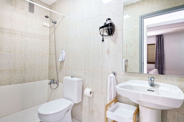 Une salle de bain avec des toilettes, un lavabo et une douche.