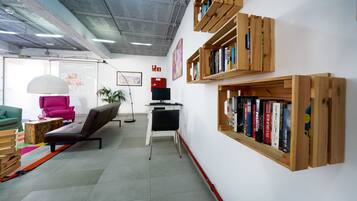 A modern office space with a desk, chair, bookshelf, and a plant.
