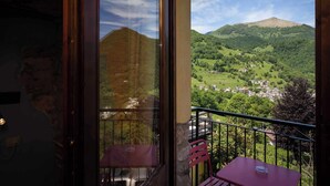 A balcony with a view of a green valley and mountains. - Agriturismo Al Marnich (Schignano)