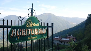 A sign for 'Agriturismo Al Marnich' with a mountain view in the background. - Agriturismo Al Marnich (Schignano)