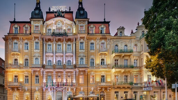 Un hotel imponente con arquitectura ornamentada, varios balcones y una entrada destacada.
