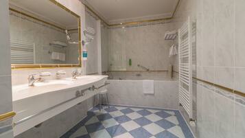 A bathroom with a checkered floor, a large mirror, a bathtub, and a shower area.