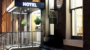 L’entrée d’un hôtel, avec une enseigne indiquant « Dergale Hotel » et « Ostian Hotel ».